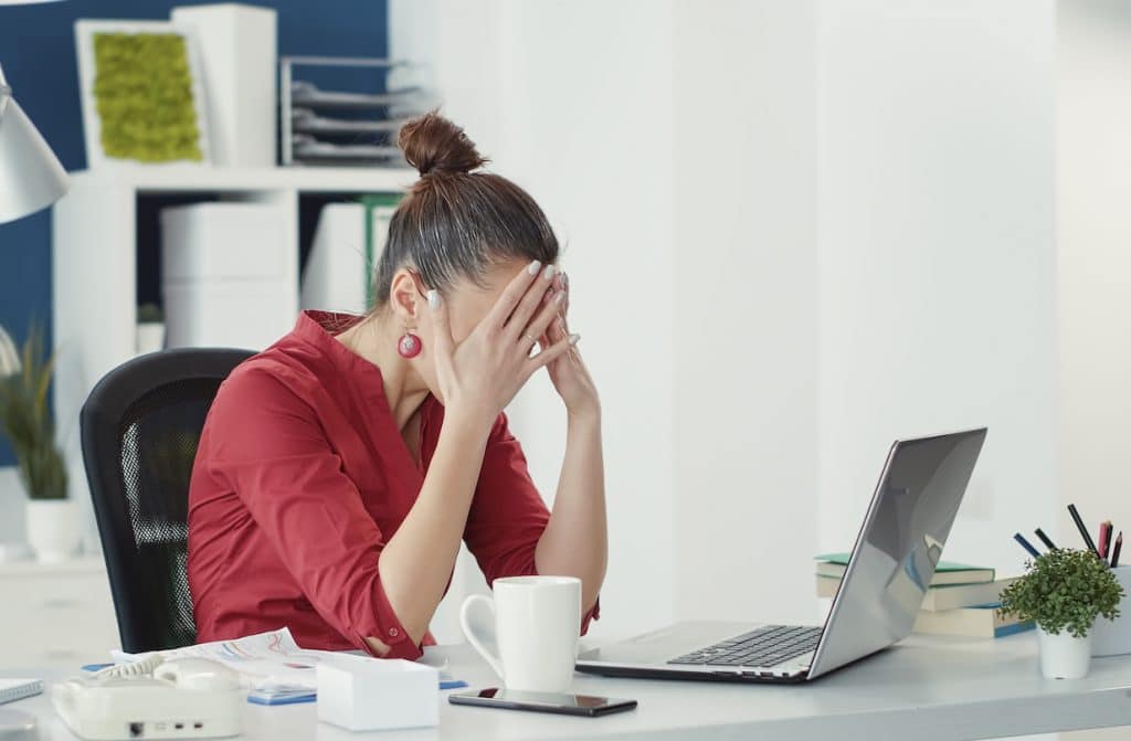 stressed employee at desk making marketing mistake at office start-up